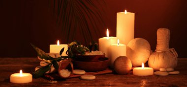 Karanlık arka planda mum ve spa malzemeleri yakmak  
