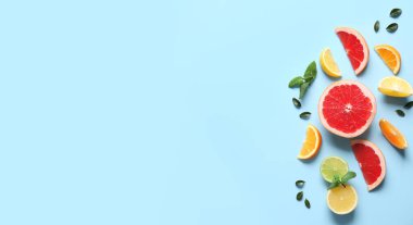 Açık mavi zemin üzerinde birçok farklı kesim narenciye meyveleri metin ve üst görünüm için yer ile