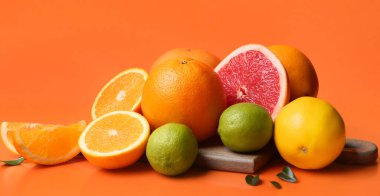 Turuncu arka planda birçok farklı turunçgil meyvesi