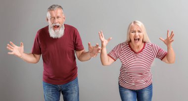 Gri arka planda kızgın olgun bir çift.