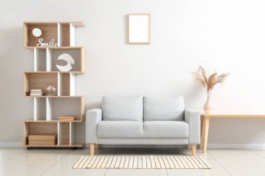 Stylish grey sofa in interior of living room