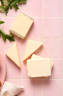 Pembe kaplama üzerinde işlenmiş peynir ve bitkiler