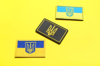 Sarı arka planda mızrak bulunan Ukrayna ordusunun farklı askeri rozetleri.