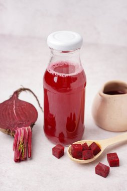 Hafif arka planda bir şişe taze pancar suyu.