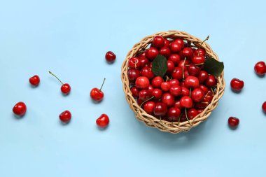 Mavi arka planda kirazlı hasır kase.