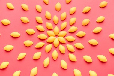 Kırmızı arkaplanda pişmemiş makarna