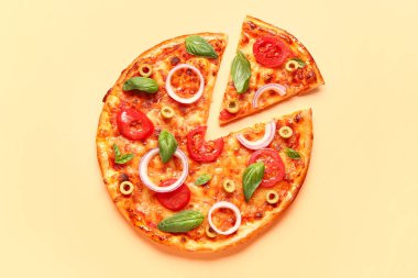 Zeytinli, domatesli ve bej arka planda fesleğenli lezzetli pizza.