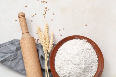 Buğday unu, dikenler ve beyaz masa üzerinde merdane.