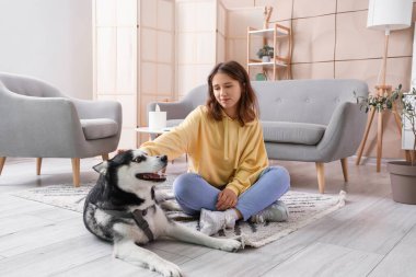 Evde köpekli mutlu genç bir kadın.