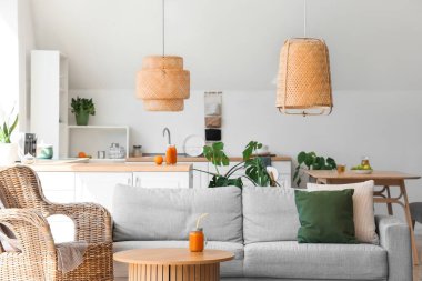 Koltuğu, koltuğu ve çiçekleri olan aydınlık mutfağın içi.