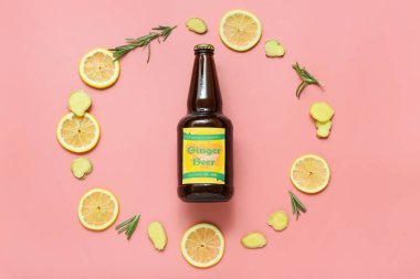 Pembe arka planda taze zencefilli bira, biberiye ve limon dilimleri ile kompozisyon