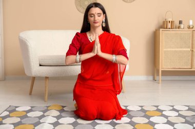 Sarili genç ve güzel bir Hintli kadın evde dua ediyor. Divaly kutlaması