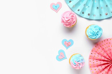 Beyaz arka planda soru işaretleri ve süslemeleri olan lezzetli kekler. Cinsiyet ortaya çıkan parti kavramı