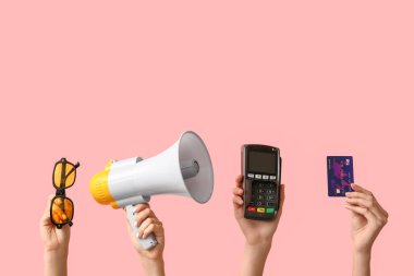 Güneş gözlüklü kadın eller, megafon, kredi kartı ve pembe arka planda ödeme terminali. Kara Cuma indirimi