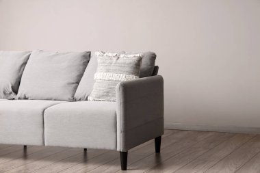 Oturma odasında yastıklı gri kanepe.