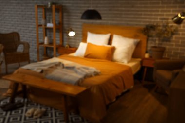 Gece yatak odasının bulanık manzarası, parlayan lambalar ve ahşap banklar.