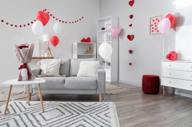 Sevgililer Günü için dekore edilmiş aydınlık oturma odasının içi kanepe, kalp ve balonlarla dolu.