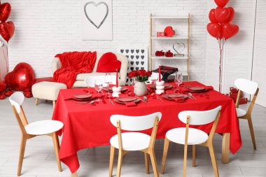 Sevgililer Günü 'nde evde kırmızı güller ve mumlarla süslenmiş şenlik masası.