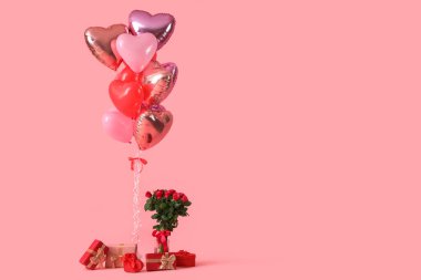 Heart-shaped balloons with gift boxes and bouquet of roses on pink background. Valentine's Day celebration