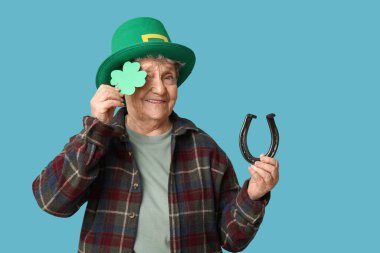 Mavi arka planda at nalı ve yonca olan cüce şapkalı yaşlı kadın. Aziz Patrick Günü kutlaması