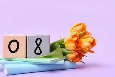 Küp takvimi, tarih 08, güzel turuncu laleler ve eflatun arkaplan üzerine not defterleri. Uluslararası Kadınlar Günü