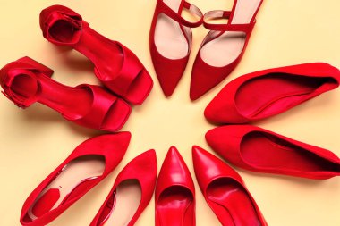 Bej arka planda kırmızı kadının ayakkabılarından yapılmış bir çerçeve. Üst görünüm