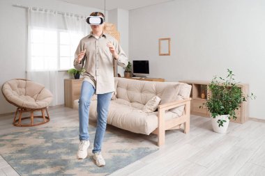VR gözlüklü genç adam evde.