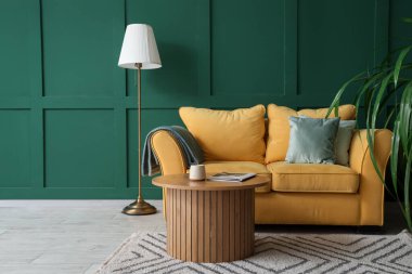 Konforlu kanepe, kahve masası ve oturma odasının iç tarafındaki saksı.