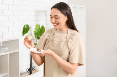 Çikolata kaplı çilekleri olan güzel genç bir kadın.