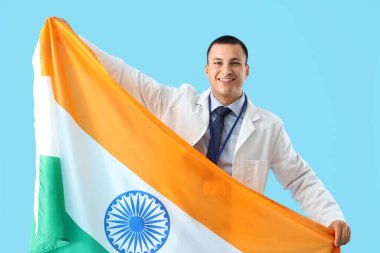 Mavi arka planda Hindistan bayrağı olan erkek doktor. Ulusal Doktorların Günü kutlaması