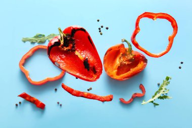 Mavi arka planda roka ve biberli leziz ızgara biber.