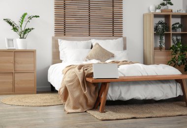 Bankı ve dizüstü bilgisayarı olan şık bir yatak odası.