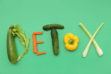 Yeşil arka planda taze sebzelerden yapılmış DETOX kelimesi