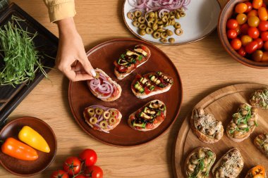 Masada vejetaryen bruschetta pişiren bir kadın.