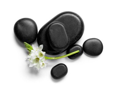 Siyah spa taşları ve beyaz arka planda güzel çiçekli kompozisyon