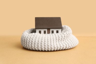 Bej arka planda sıcak eşarplı ev modeli. Isınma mevsimi kavramı