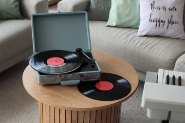 Oturma odasındaki masada vinil disklerle müzik çalar