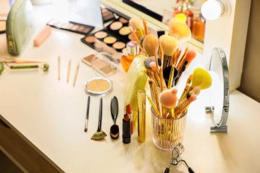 Makyaj çantası, makyaj malzemeleri ve aksesuarlar odadaki tuvalet masasında.