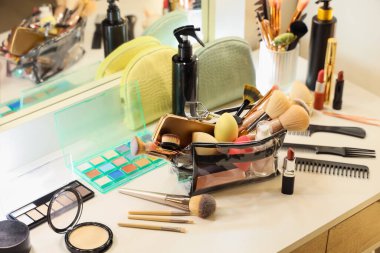 Makyaj çantası, makyaj malzemeleri ve aksesuarlar odadaki tuvalet masasında.