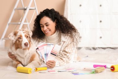 Palet örnekleriyle mutlu bir Afro-Amerikan ressam ve yeni evdeki tamirat sırasında yalan söyleyen tatlı bir Avustralya çoban köpeği.