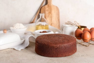 İçindekilerle çikolatalı kek ve arka planda mutfak aletleri.