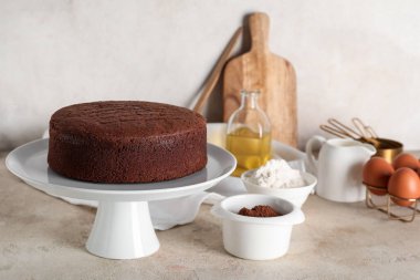 Hafif grunge arka planında kakao tozu, yumurta ve un ile lezzetli çikolatalı kek.