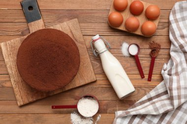 Ahşap arka planda malzemeleri olan lezzetli çikolatalı kek.