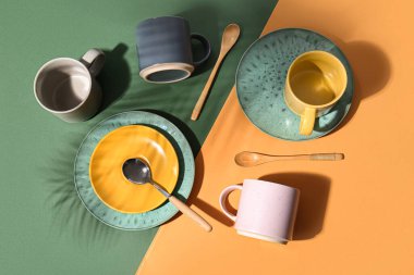 Renk arkaplan üzerinde kupalar, plakalar ve kaşıklar ile kompozisyon