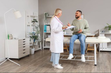 Klinikte genç bir adamla çalışan kadın doktor.