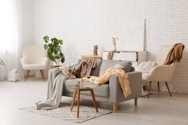 Kanepenin üzerinde dağınık giysiler olan dağınık bir soyunma odası.