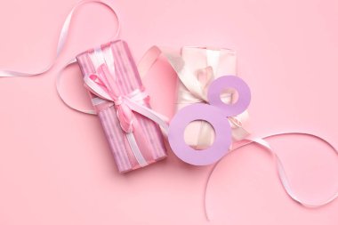 Hediye kutularıyla kompozisyon ve pembe arka planda kağıttan yapılmış 8 figür