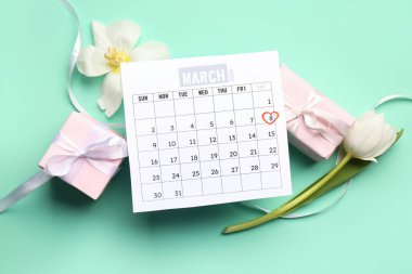 Lale çiçekleri, takvim ve hediye kutlaması için yeşil arka planda.