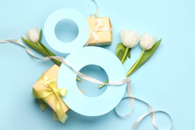 Kağıtlardan, lale çiçeklerinden ve Kadınlar Günü kutlamaları için mavi arka planda hediye kutularından yapılmış 8 figür.