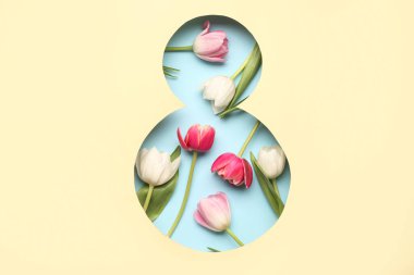 Mavi arka planda güzel lale çiçekleri olan, şekil 8 şeklinde bej bir kağıt kes. Uluslararası Kadınlar Günü.